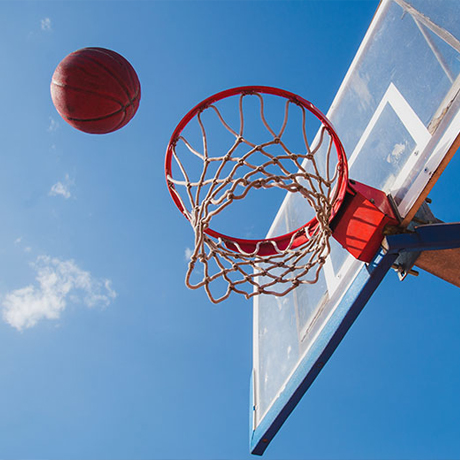 Basketball hoop with blue sky.